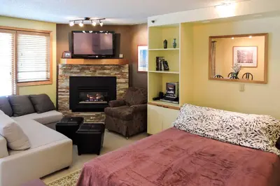 a living room with a couch and a fireplace at Cozy Ski-InandSki-Out Winter Park Resort Condo! in Winter Park