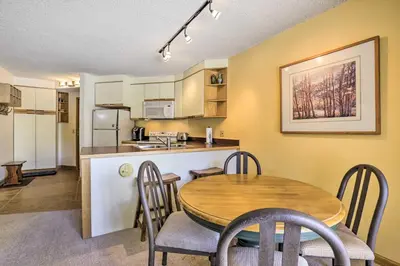 a kitchen and dining room with a table and chairs at Cozy Ski-InandSki-Out Winter Park Resort Condo! in Winter Park
