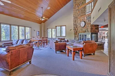 a living room with leather furniture and a stone wall at Cozy Ski-InandSki-Out Winter Park Resort Condo! in Winter Park