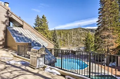 a house with a balcony with a swimming pool at Cozy Ski-InandSki-Out Winter Park Resort Condo! in Winter Park
