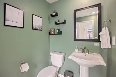 a bathroom with a sink and a toilet and a mirror at Modern & Stunning Home near Breweries and Old Town in Fort Collins