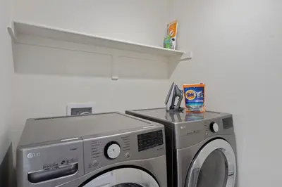 a washing machine in a room with a shelf at Modern & Stunning Home near Breweries and Old Town in Fort Collins