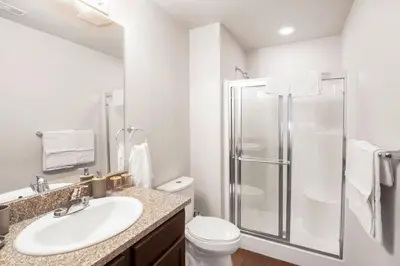 a white bathroom with a shower and a sink at Relaxing 3BR Apartment With Pool & Wifi in Greeley