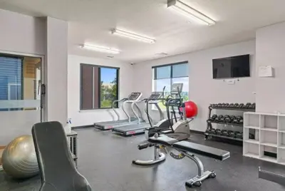 a gym with several treadmills and exercise bikes at Relaxing 3BR Apartment With Pool & Wifi in Greeley