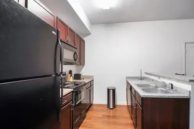 a kitchen with a black refrigerator and a sink at Relaxing 3BR Apartment With Pool & Wifi in Greeley