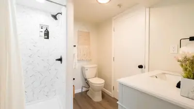 a white bathroom with a toilet and a sink at Sloans Lake Walk to eateries bars Free parking in Denver