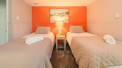 two beds in a room with orange walls at Sloans Lake Walk to eateries bars Free parking in Denver