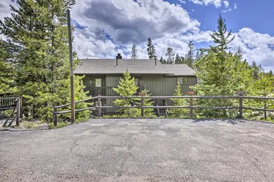 a house with a fence in front of a driveway at Grand Lake Condo with Mountain Views Walk to Lake! in Grand Lake