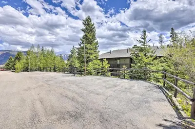 an empty road in front of a house with a fence at Grand Lake Condo with Mountain Views Walk to Lake! in Grand Lake