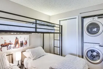 a bedroom with a bunk bed and a washing machine at Idyllic Condo about 5 Mi to Winter Park Resort! in Winter Park