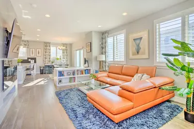 a living room with an orange couch and a blue rug at Private Balcony Pet-Friendly Denver Escape! in Denver
