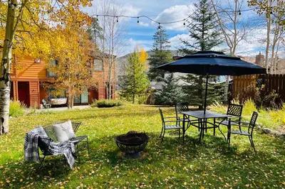 a patio with a table and chairs and an umbrella at Chic Condo with Fireplace Walk to Main St Frisco! in Frisco