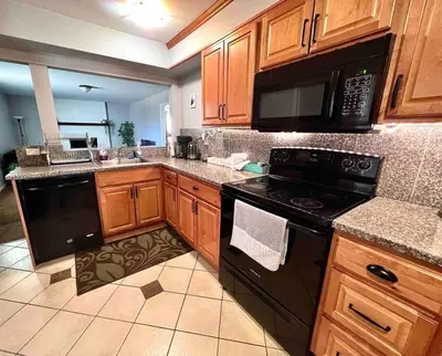 a kitchen with black appliances and wooden cabinets at Modern Home Near Downtown in Denver