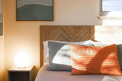 a bedroom with a bed with a wooden headboard and a lamp at Well-Appointed Family Home in Aurora/Denver Colorado in Aurora
