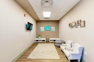 a living room with two white chairs and a tv at The Sanctuary Bldg 5 #7-8 in Winter Park
