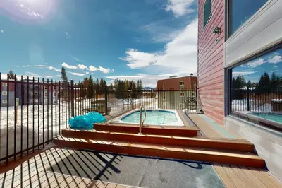a hot tub on a deck next to a fence at The Sanctuary Bldg 5 #7-8 in Winter Park