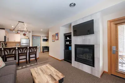a living room with a fireplace with a flat screen tv at Premium Unit 1108 - One Bedroom - Zephyr Mountain Lodge condo in Winter Park