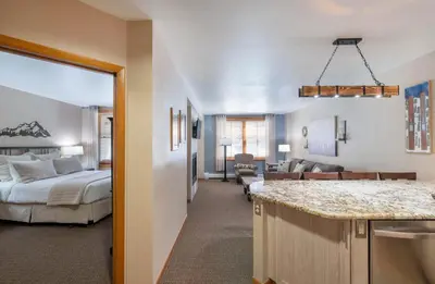 a room with a bed and a kitchen with a counter at Premium Unit 1108 - One Bedroom - Zephyr Mountain Lodge condo in Winter Park