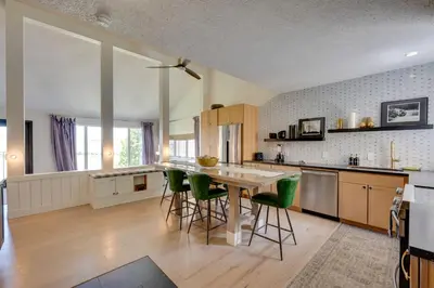 a kitchen with a wooden table and green chairs at Ski-InandSki-Out Granby Ranch Condo with Mountain View in Granby