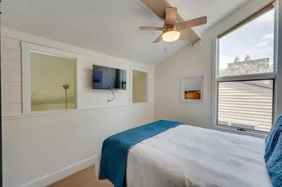 a bedroom with a bed with a ceiling fan and a window at Ski-InandSki-Out Granby Ranch Condo with Mountain View in Granby