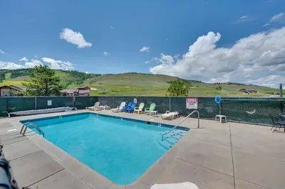 a swimming pool with a hill in the background at Ski-InandSki-Out Granby Ranch Condo with Mountain View in Granby