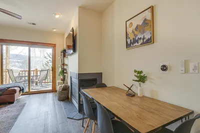 a living room with a table and a fireplace at Winter Park Condo with Balcony and Mtn Views! in Winter Park