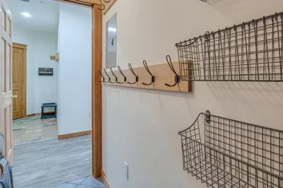a room with a wall with hangers on a wall at Winter Park Condo with Balcony and Mtn Views! in Winter Park