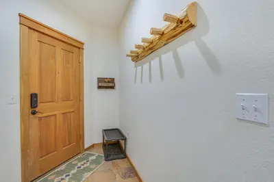 a hallway with a wooden door and a rug at Winter Park Condo with Balcony and Mtn Views! in Winter Park