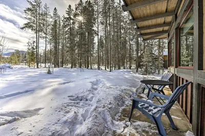 a table and a chair on a porch in the snow at Cozy Fraser Cabin with Views and Moose Sightings! in Fraser