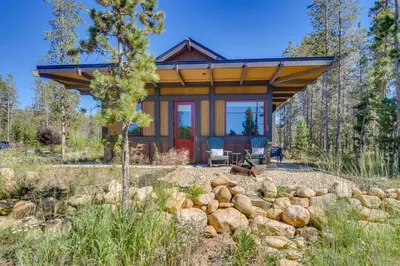 a cabin in the woods with a pile of rocks at Cozy Fraser Cabin with Views and Moose Sightings! in Fraser