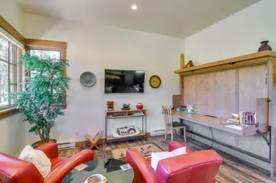 a living room with red chairs and a table at Cozy Fraser Cabin with Views and Moose Sightings! in Fraser