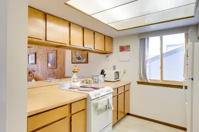 a kitchen with wooden cabinets and a white stove at Fraser Mountain Retreat with Community Amenities! in Fraser