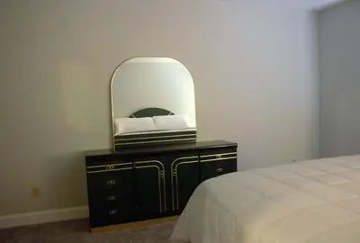 a bedroom with a mirror on a dresser with a bed at Amazing 4 Bedroom House with nice Backyard in Littleton