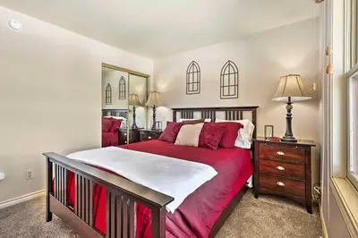 a bedroom with a large bed with a red blanket at 3 Mi to National Park Cozy Studio in Grand Lake in Grand Lake