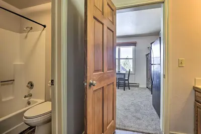 a bathroom with a toilet and a sink and a door at 3 Mi to National Park Cozy Studio in Grand Lake in Grand Lake
