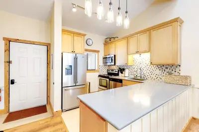 a kitchen with wooden cabinets and a white refrigerator at Coziest Condo in Winter Park