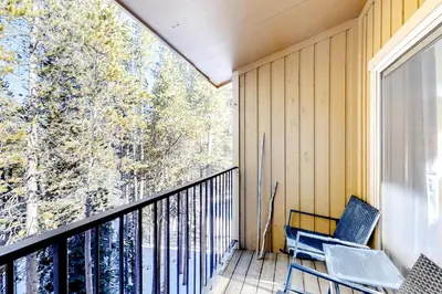 a balcony with a chair and a large window at Coziest Condo in Winter Park