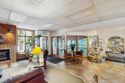 a living room with a christmas tree in it at Coziest Condo in Winter Park