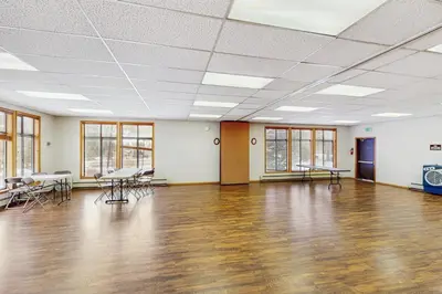 a large room with a wooden floor and tables and chairs at Coziest Condo in Winter Park