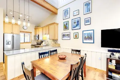 a kitchen and dining room with a wooden table and chairs at Coziest Condo in Winter Park