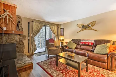 a living room with a leather couch and a fireplace at Gorgeous Winter Park Condo with Private Deck! in Winter Park