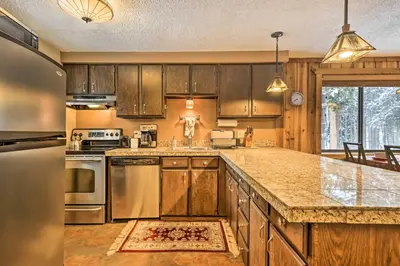 a kitchen with wooden cabinets and stainless steel appliances at Gorgeous Winter Park Condo with Private Deck! in Winter Park