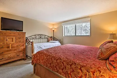 a bedroom with a bed and a dresser and a television at Gorgeous Winter Park Condo with Private Deck! in Winter Park