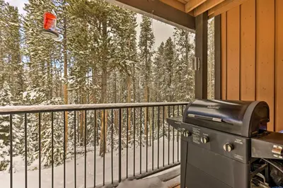a grill on a screened in porch with snow covered trees at Gorgeous Winter Park Condo with Private Deck! in Winter Park