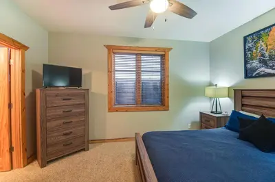 a bedroom with a bed and a flat screen tv at Patio and Mountain Views Central Grand Lake Condo! in Grand Lake