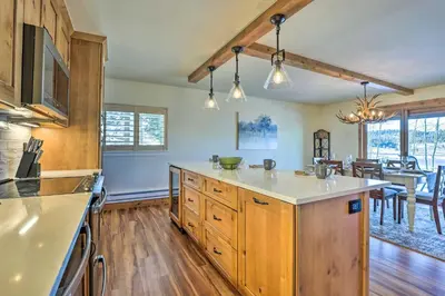 a kitchen with wooden cabinets and a dining room at MtnandLake Views and 3 Mi to Skiing Dillon Condo in Dillon
