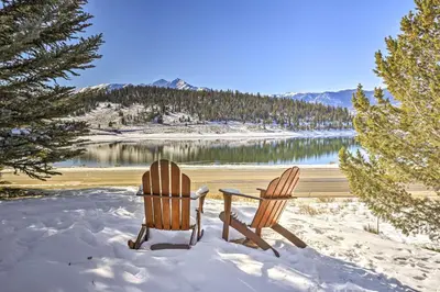 two chairs sitting in the snow next to a lake at MtnandLake Views and 3 Mi to Skiing Dillon Condo in Dillon
