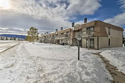 a snow covered street in front of a building at Walk to Winter Park Bus From Fraser Condo! in Fraser