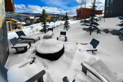 a yard covered in snow with chairs and tables at A Slice of Silverthorne in Silverthorne