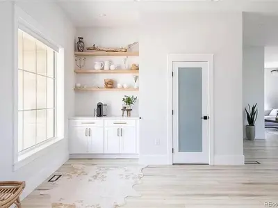 a white kitchen with white cabinets and a door at New! Pure Luxury W Private Pool/Spa & Game Center! in Arvada